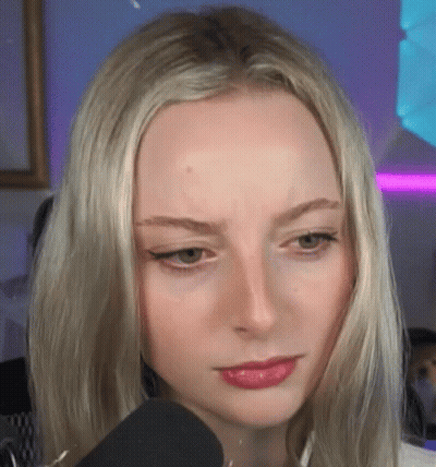 A Close Up Of A Blonde Woman 'S Face With A Microphone In Front Of Her . GIF