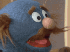 A Close Up Of A Blue Puppet With Big Eyes And A Red Tongue GIF