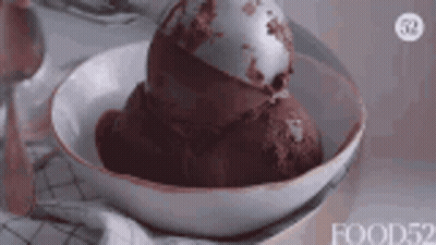 A Close Up Of A Bowl Of Chocolate Ice Cream With A Spoon In It . GIF