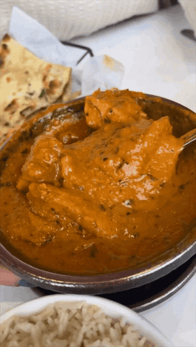 A Close Up Of A Bowl Of Curry With A Spoon In It GIF