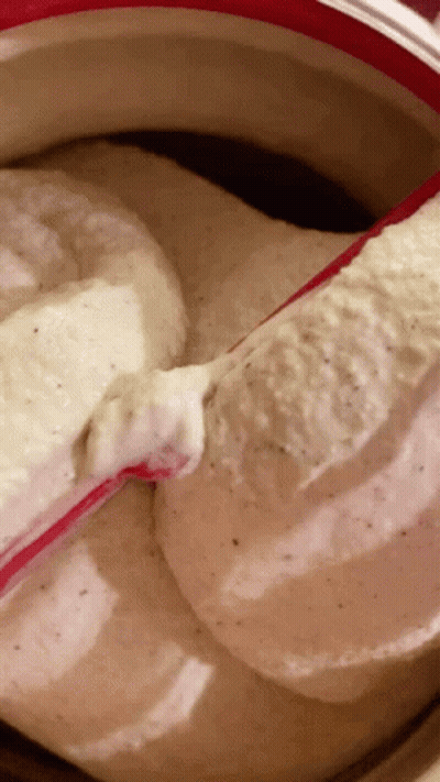 A Close Up Of A Bowl Of Ice Cream With A Red Spoon In It GIF