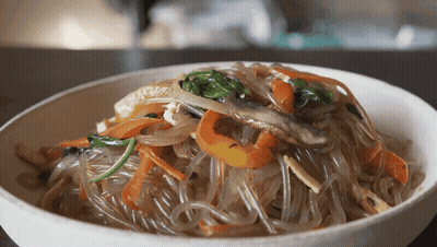 A Close Up Of A Bowl Of Noodles With Vegetables GIF