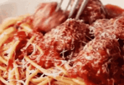 A Close Up Of A Bowl Of Spaghetti And Meatballs With A Fork . GIF