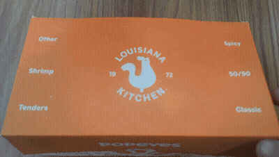 A Close Up Of A Box Of Donut Holes With The Word Donut In White Letters GIF