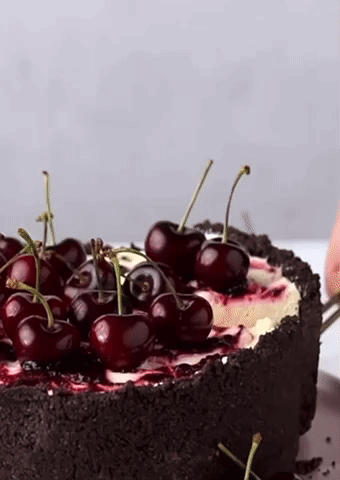 A Close Up Of A Cake With Cherries On Top Of It GIF
