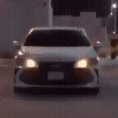 A Close Up Of A Car 'S Headlights Glowing In The Dark GIF