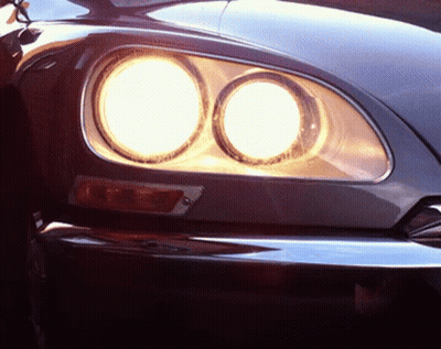 A Close Up Of A Car 'S Headlights That Are Lit Up GIF