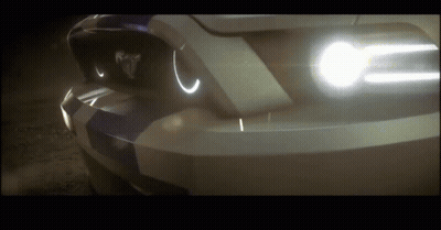 A Close Up Of A Car 'S Headlights With The Word Mustang On The Front GIF