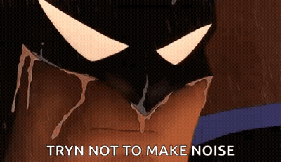 A Close Up Of A Cartoon Batman 'S Face With The Words `` Tryn Not To Make Noise '' Written On It . GIF