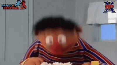 A Close Up Of A Cartoon Character Eating Rice With A Party & Festival Nl Logo In The Background . GIF