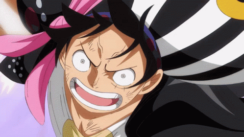 A Close Up Of A Cartoon Character 'S Face With A Pink Flower In His Hair GIF