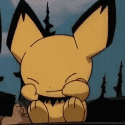 A Close Up Of A Cartoon Character Sitting On A Table With Its Eyes Closed . GIF