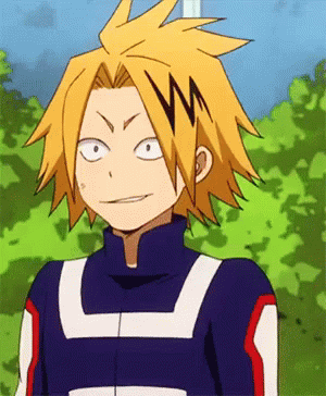 A Close Up Of A Cartoon Character With Yellow Hair Wearing A Blue Jacket . GIF