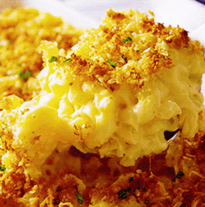 A Close Up Of A Casserole Dish With Macaroni And Cheese On A Spoon GIF