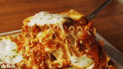 A Close Up Of A Casserole Dish With The Word Delish On The Bottom Right GIF