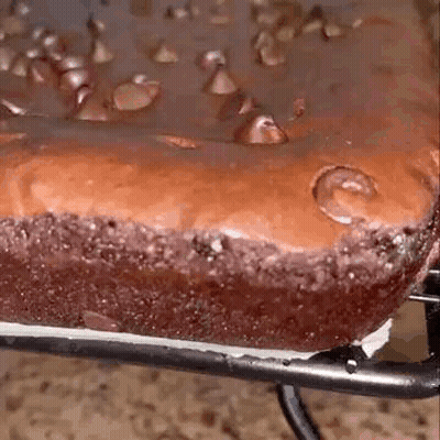 A Close Up Of A Chocolate Brownie With Chocolate Chips On Top On A Cooling Rack . GIF