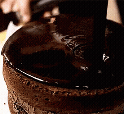 A Close Up Of A Chocolate Cake Being Covered In Chocolate GIF