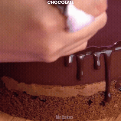 A Close Up Of A Chocolate Cake Being Decorated GIF