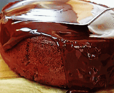 A Close Up Of A Chocolate Cake With A Spoon Sticking Out Of It GIF