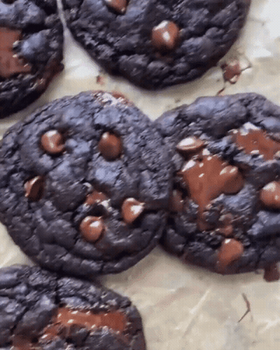 A Close Up Of A Chocolate Chip Cookie On A Table GIF
