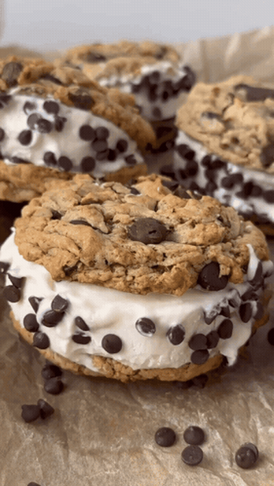 A Close Up Of A Chocolate Chip Cookie Sandwich On A Table GIF