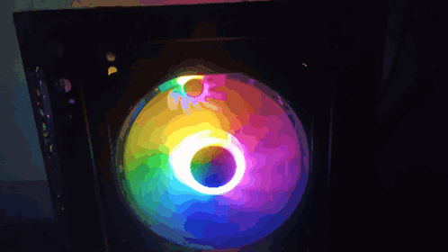 A Close Up Of A Computer Fan With A Rainbow Colored Light Behind It GIF