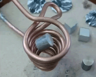 A Close Up Of A Copper Coil With A Piece Of Metal Inside GIF