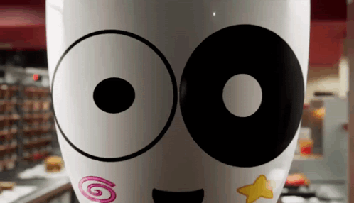A Close Up Of A Cup With A Smiley Face And A Star On It GIF