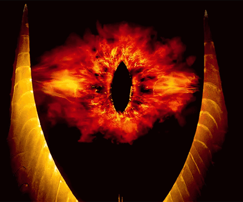 A Close Up Of A Demon 'S Eye With Flames Surrounding It GIF