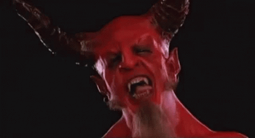 A Close Up Of A Devil With Horns And Fangs On A Black Background . GIF
