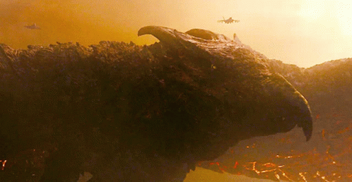 A Close Up Of A Dinosaur 'S Head With A Helicopter In The Background GIF