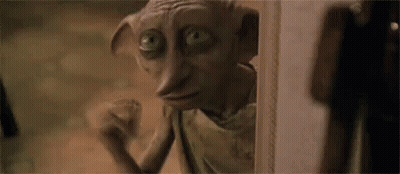 A Close Up Of A Dobby From Harry Potter Looking Out Of A Doorway . GIF