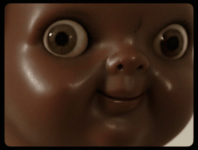 A Close Up Of A Doll Face With Big Eyes GIF
