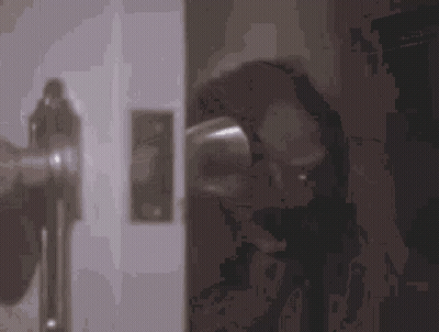 A Close Up Of A Door Handle With A Reflection Of A Person Behind It . GIF