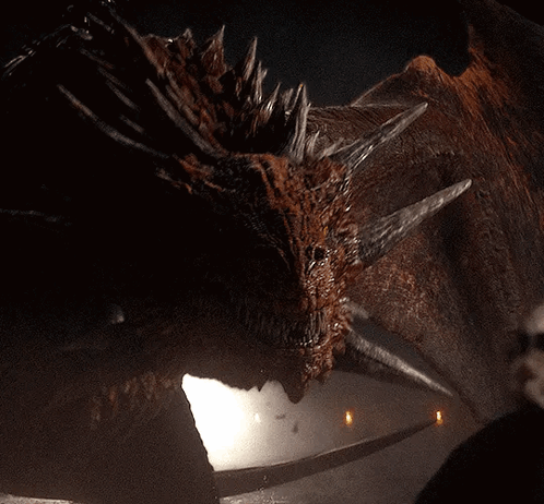 A Close Up Of A Dragon 'S Face With A Few Lights In The Background GIF