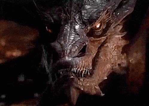A Close Up Of A Dragon 'S Face With Its Eyes Glowing GIF
