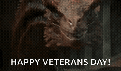 A Close Up Of A Dragon With The Words `` Happy Veterans Day '' Written Below It . GIF