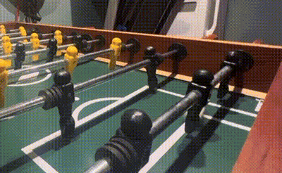 A Close Up Of A Foosball Table With Yellow And Black Players GIF
