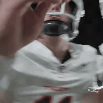 A Close Up Of A Football Player Wearing A Helmet And Headphones . GIF