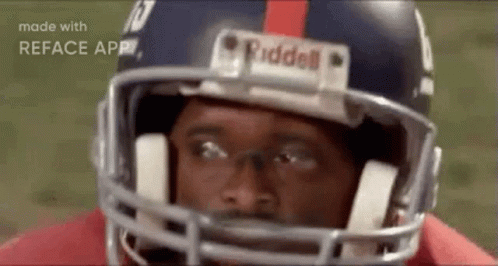 A Close Up Of A Football Player Wearing A Helmet And Looking At The Camera . GIF