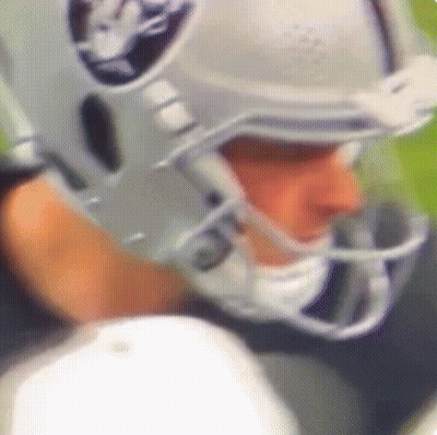 A Close Up Of A Football Player Wearing A Helmet That Says Raiders On It GIF