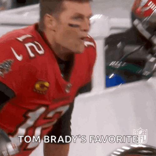 A Close Up Of A Football Player Wearing A Red Jersey With The Words Tom Brady 'S Favorite . GIF