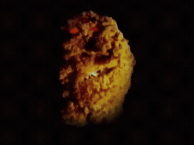 A Close Up Of A Fried Chicken Nugget With Red Eyes GIF