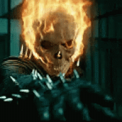 A Close Up Of A Ghost Rider With Flames Coming Out Of His Face GIF