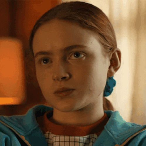 A Close Up Of A Girl 'S Face Wearing A Blue Jacket GIF