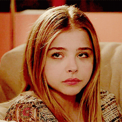 A Close Up Of A Girl 'S Face With A Floral Shirt On GIF