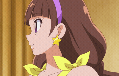 A Close Up Of A Girl 'S Face With A Purple Headband And Yellow Earrings GIF