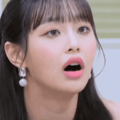 A Close Up Of A Girl 'S Face With Her Mouth Open And Earrings . GIF