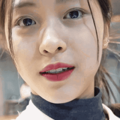 A Close Up Of A Girl 'S Face With Red Lipstick On Her Lips GIF