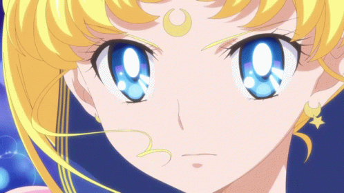 A Close Up Of A Girl With Blue Eyes And A Crescent Moon On Her Head GIF